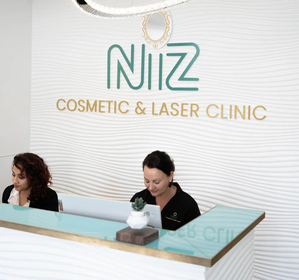 NiZ Clinic - Two female employees seated at the reception of NiZ cosmetic and laser Clinic, gold coast - Australia.